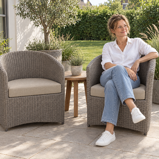 Lachende Frau im Rattansessel auf einem halbrunden Outdoor Lounge Sitzkissen nach Maß in Beige auf der Terrasse